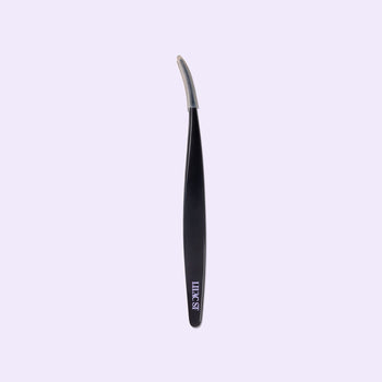 Black Lilac St. lash applicator with curved precision tip on a soft lilac background.