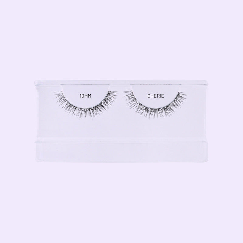 Lilac St. Cherie 10mm lash clusters arranged in a clear tray against a soft lilac background.