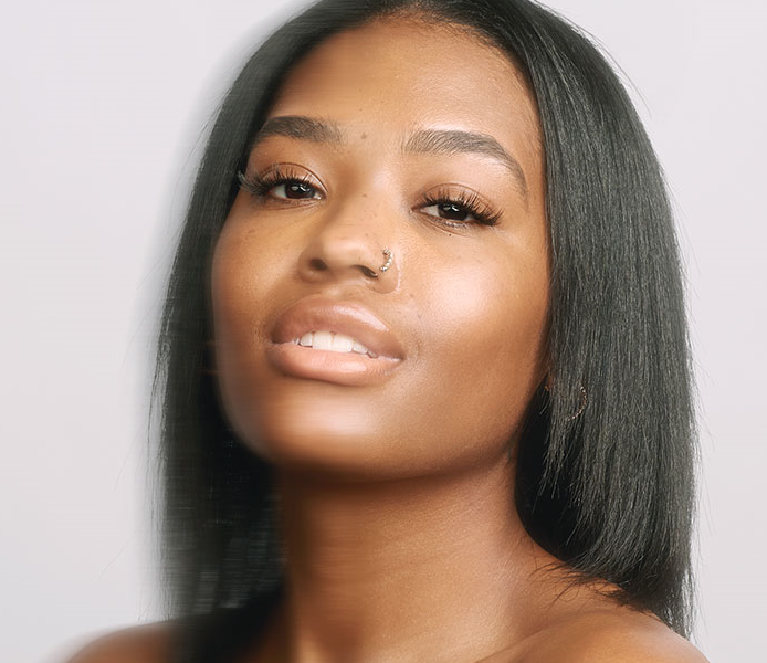Close-up portrait of a woman with straight dark hair and naturally defined lash extensions.